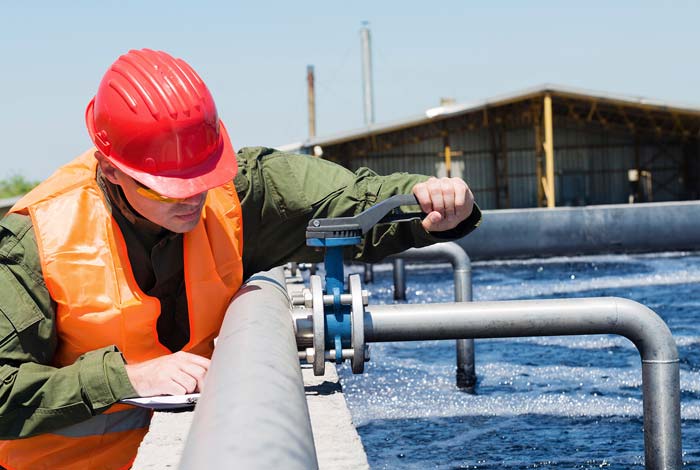 national water hygiene worker performing tests on a water supply pipe